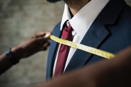 Un couturier mesure un costume.